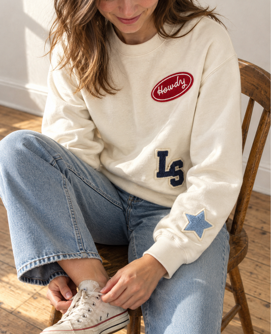 Woman wearing a cream patch crewneck with monogram letters and a star patch, a personalized gift for the bride