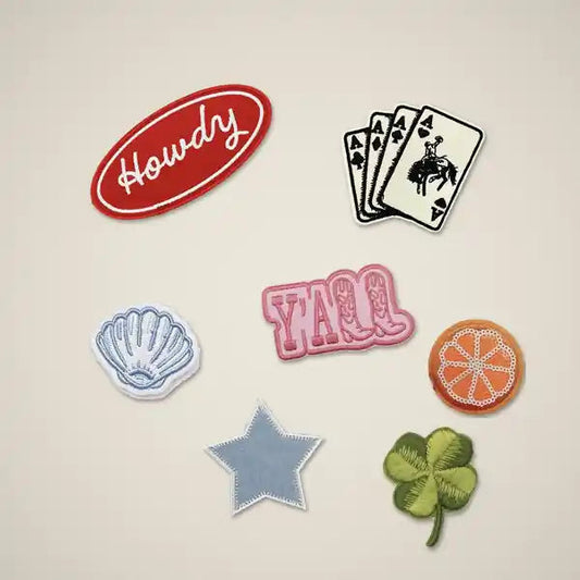 Set of custom embroidered patches including Howdy, seashell, four aces and clover