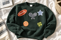 Green patch crewneck sweatshirt with Howdy, tennis rackets, denim star, orange slice and clover embroidered patches