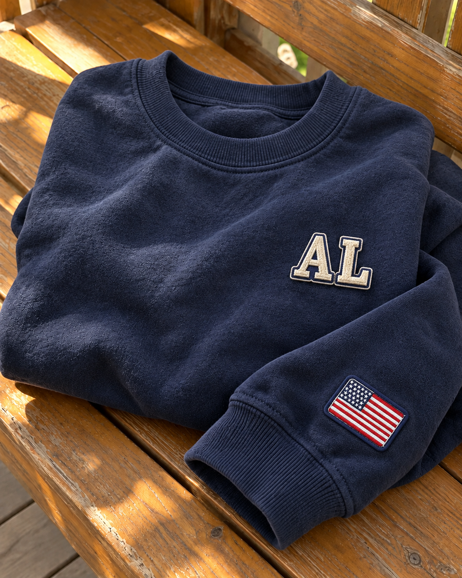 Close-up of embroidered patches on a grey crewneck