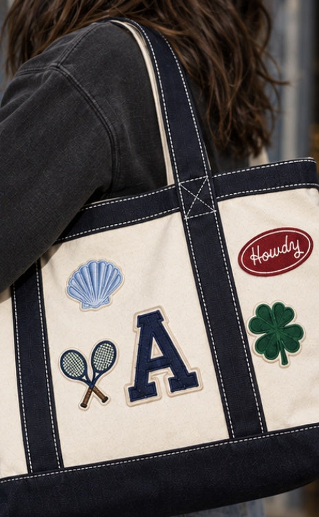 Woman carrying The Everyday Tote with seashell, tennis rackets, A letter, Howdy and clover patches